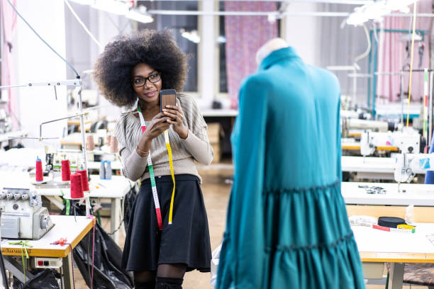 istock Female designer with tape measure using phone 1085803018