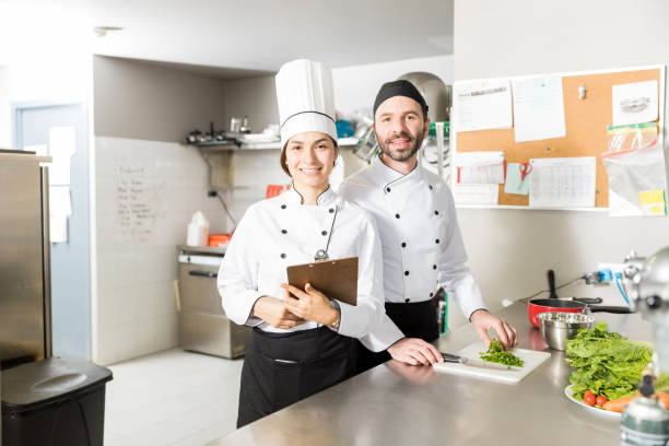 istock Cooks With Clipboard And Vegetables In Kitchen 1085831906