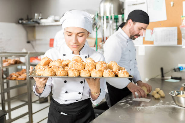 chef creativo teniendo aroma de pasteles horneados - smelling bread bakery women fotografías e imágenes de stock