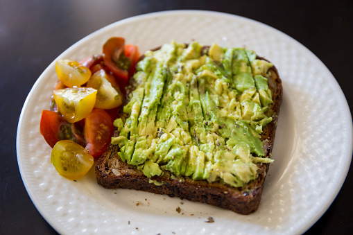 Healthy green veggie avocado toast with tomatoes