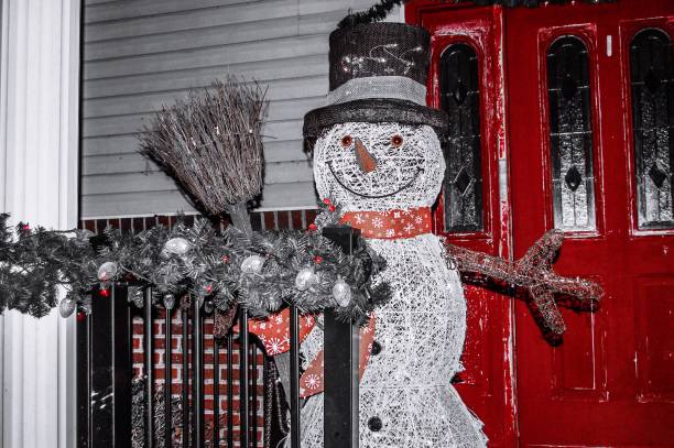 Snowman Decoration on the front porch in front of a worn red door.