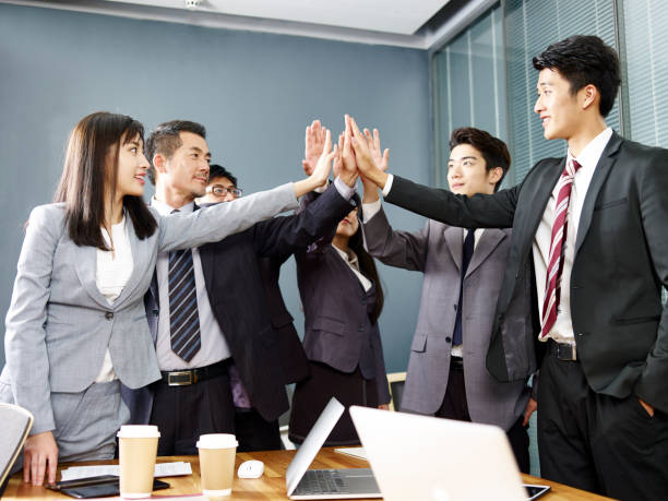 istock asian business team putting hands together to show unity 1085848490
