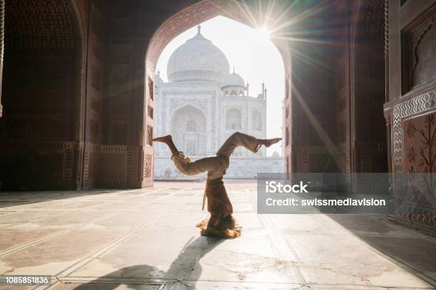 Young Woman Practicing Yoga In India At The Famous Taj Mahal At Sunrise Headstand Position Upside Down People Travel Spirituality Zen Like Concept Stock Photo - Download Image Now