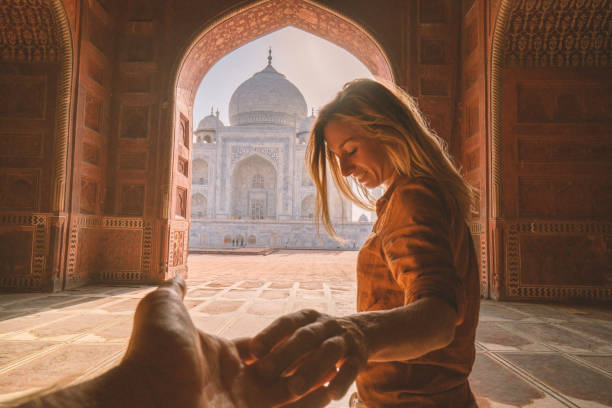 Follow me to the Taj Mahal, India. Female tourist leading boyfriend to there magnificent famous Mausoleum in Agra. People travel concept Follow me to the Taj Mahal, India. Female tourist leading boyfriend to there magnificent famous Mausoleum in Agra. People travel concept india indian culture taj mahal temple stock pictures, royalty-free photos & images