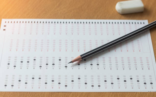 istock Black pencil on paper computer sheet and eraser on table.  Standardized test form with answers bubble. Multiple choice answer sheets. Ideas about education. 1085861870