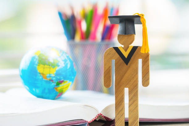 istock America Education knowledge learning study abroad international Ideas. People Sign wood with Graduation celebrating cap on open textbook with model global map, alternative studying world wide 1085872968
