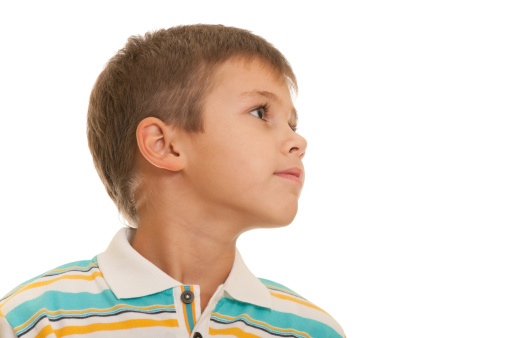 A closeup profile portrait of a seven-year-old kid isolated on the white background