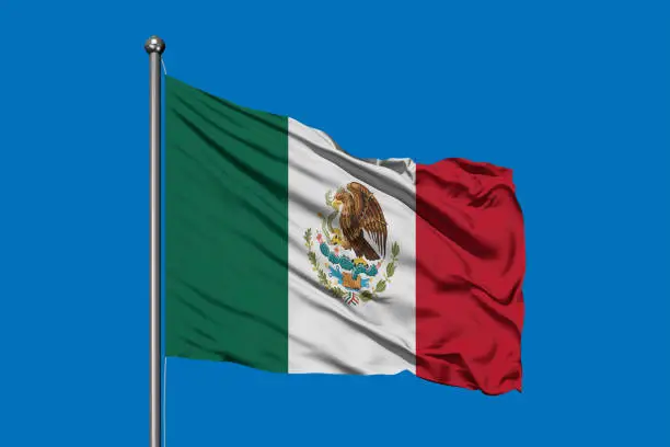 Photo of Flag of Mexico in the wind against deep blue sky. Mexican flag.