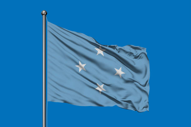 flag of micronesia waving in the wind against deep blue sky. federated states of micronesia flag. - federated imagens e fotografias de stock