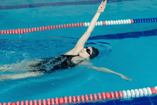 istock Young girl in goggles and cap swimming backstroke 1085882726