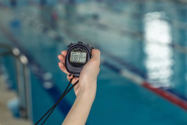 close-up of coach hand holding stopwatch at poolside - time duration imagens e fotografias de stock