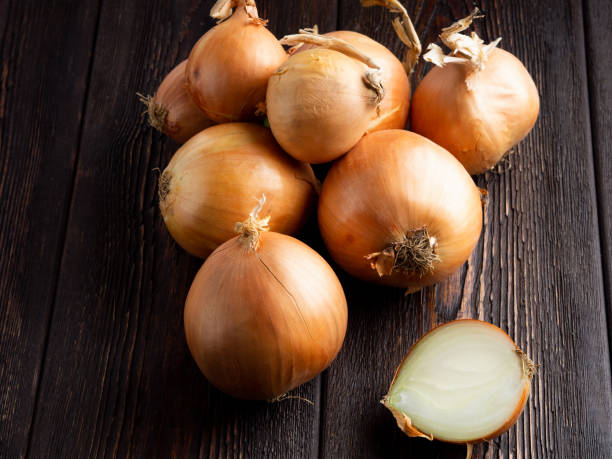 istock Onion on a dark brown wooden background 1085893980
