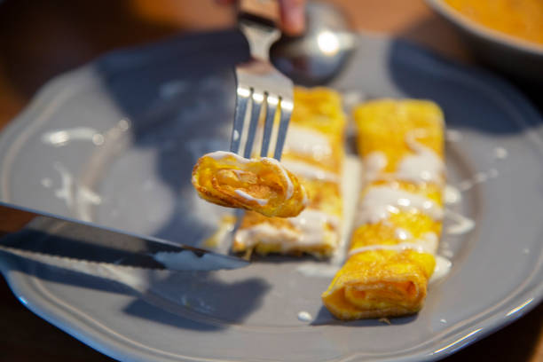 A folded omelets served with herbs and tomatoes