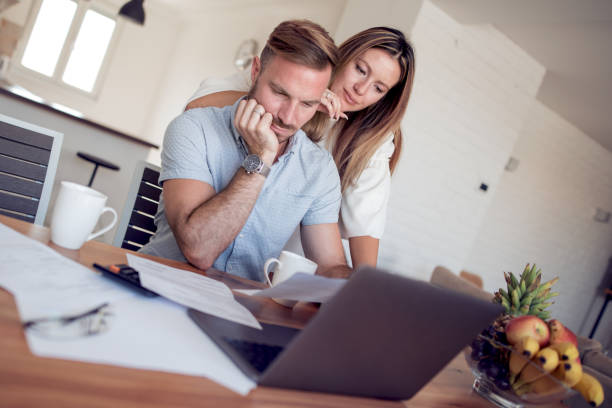 istock Young couple checking their bills at home 1085902612