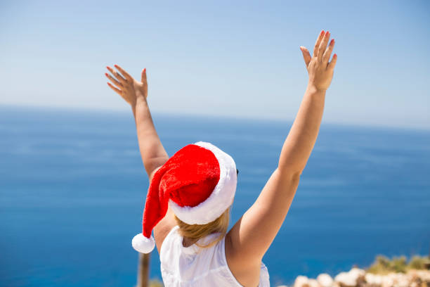 istock Woman on the beach in santa's hat 1085908672
