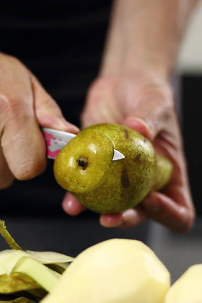 istock Peeling pears. Making Chocolate, Pear and Pecan Pie Series. 1085910220