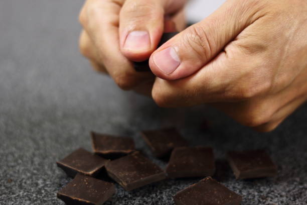 istock Breaking chocolate bar on pieces. Making Chocolate, Pear and Pecan Pie Series. 1085910736