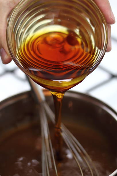 istock Pouring golden syrup into chocolate mixture. Making Chocolate, Pear and Pecan Pie Series. 1085912142