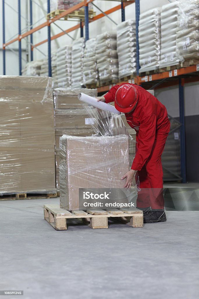 Travailleur boîte d'emballage sur palette en bois dans un entrepôt - Photo de Palette de chargement libre de droits