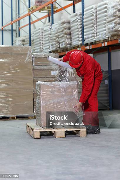 Photo libre de droit de Travailleur Boîte Demballage Sur Palette En Bois Dans Un Entrepôt banque d'images et plus d'images libres de droit de Palette de chargement