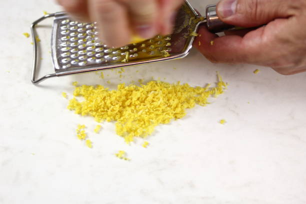 istock Chef shredding lemon with grater. Making Lemon Mascarpone Pie Series. 1085920914