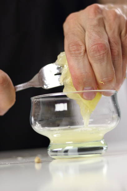 istock Juice lemon half with assistance of fork. Making Lemon Mascarpone Pie Series. 1085921130