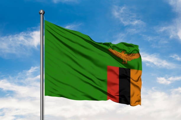 Flag of Zambia waving in the wind against white cloudy blue sky. Zambian flag. Flag of Zambia waving in the wind against white cloudy blue sky. Zambian flag. zambia flag stock pictures, royalty-free photos & images