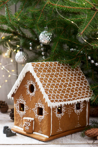 istock Gingerbread house and Christmas trees on a luminous background. Bokeh effect. 1085928048