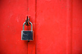 Stainless steel padlock and red door gate