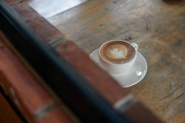 istock Coffee latte in white cup on wooden table 1085928906