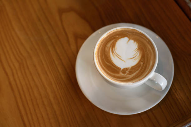 istock Coffee latte in white cup on wooden table 1085928928