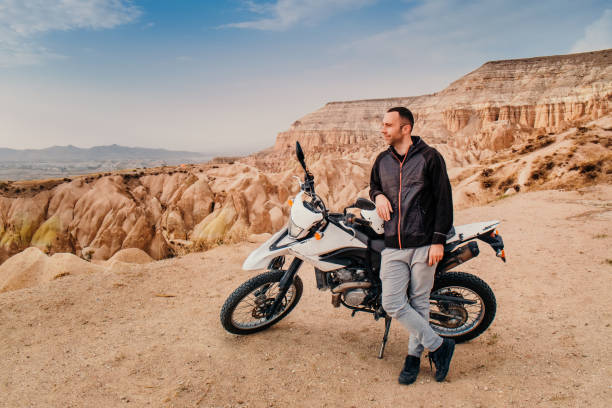 istock Man riding on motorcycle in Cappadocia mountain landscape at sunset 1085930996