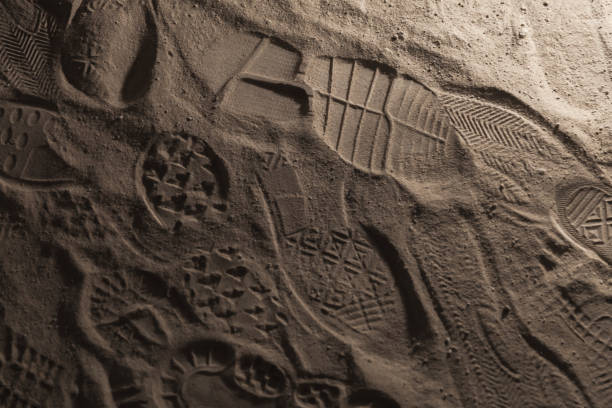 istock Footprints in dark dusty ground, background 1085936938