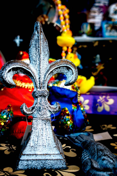 Window display of a metal Fleur de Lis souvenir item New Orleans, USA - Dec 4, 2017: Window display of a metal Fleur de Lis souvenir item in a shop along Decatur Street, French Quarter. Fleur de Lis is symbolically the state emblem of Louisiana. new orleans fleur de lis stock pictures, royalty-free photos & images