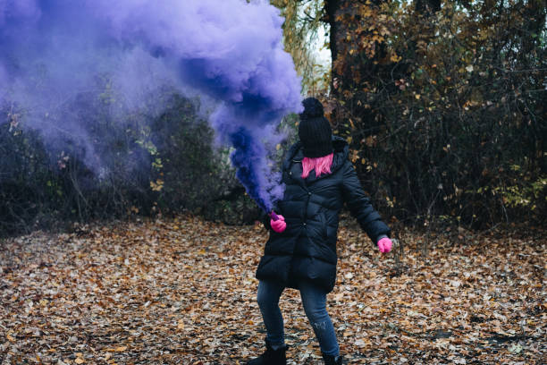 istock Woman Wearing Mask While Holding Distress Flare In Forest 1085957740