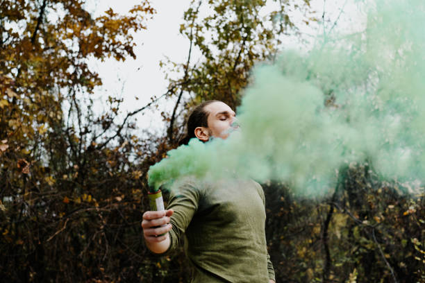 istock Young Man Holding Distress Flare While Standing In Forest 1085957782