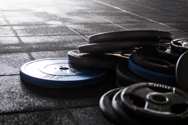Metal heavy barbell laid on the floor in gym