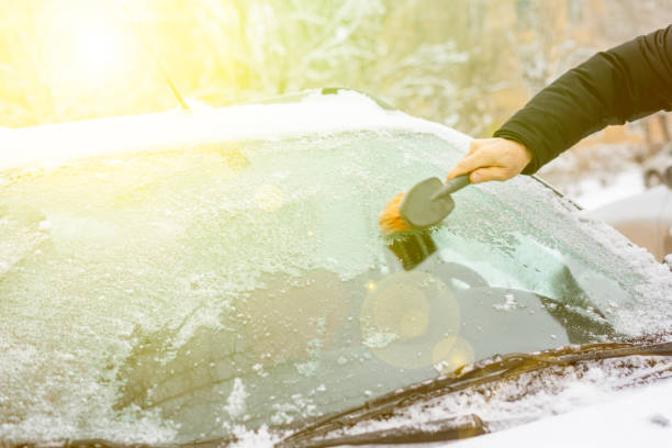 istock hand cleaning up windscreen from snow and ice in a winter season 1085962892