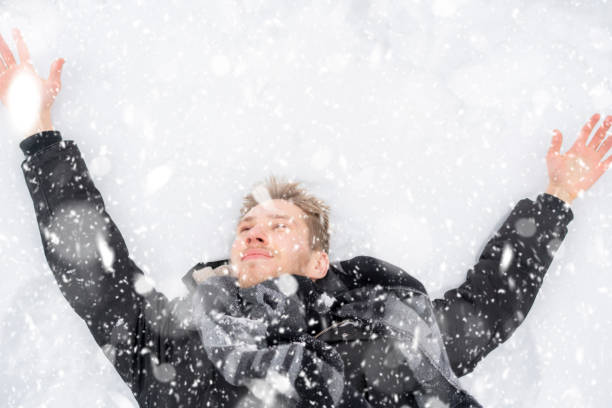 istock young man covered in snow lying on the ground in snowfall z 1085963064