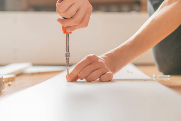 istock close up man assembling new furniture with a screwdriver b 1085963166