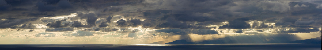 XXXL panorama - sunset over ocean. Dramatic sky, clouds and rains over coastline