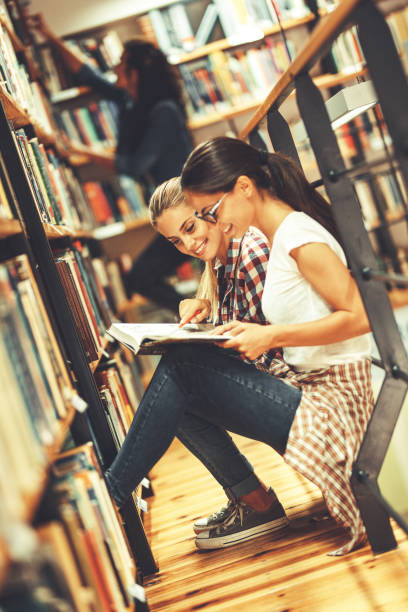 istock Two female students read and learns by the book shelf at the city library.Reading a book. 1085969582