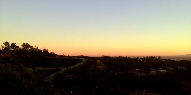 le soleil se lève sur les collines de hollywood - hollywood california skyline city of los angeles panoramic photos et images de collection