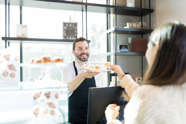 istock Woman Tasting Choux Offered By Baker 1085986638
