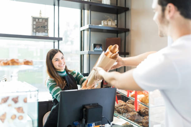 istock Saleslady Selling Bread To Young Man In Bakery 1085991332