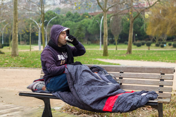 istock Homeless man is drinking coffee on bench 1085994262