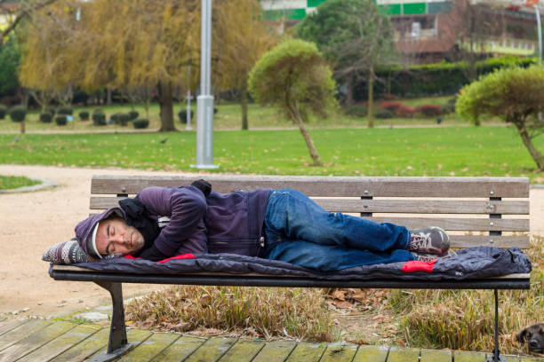istock Homeless man sleeping on bench at park 1085994276