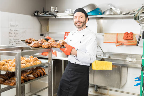 istock Smiling Baker With Baked Pastries In Restaurant Kitchen 1085994294