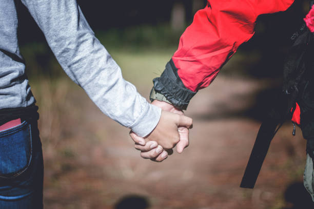 istock Young couple holding hands in forest, traveling concept 1085997978