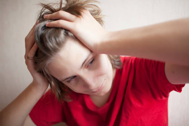istock Boy teenager in despair squeezes his head with his hands 1086011812